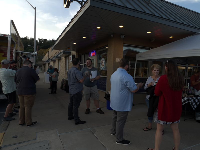 Juniata River Valley Chamber of Commerce members talking outside the One-Stop office in downtown Lewistown in the evening