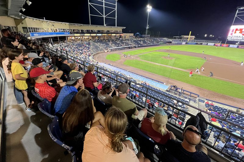 Guests watching a State College Spikes game from the upper seats at Medlar Field at Lubrano Park at night